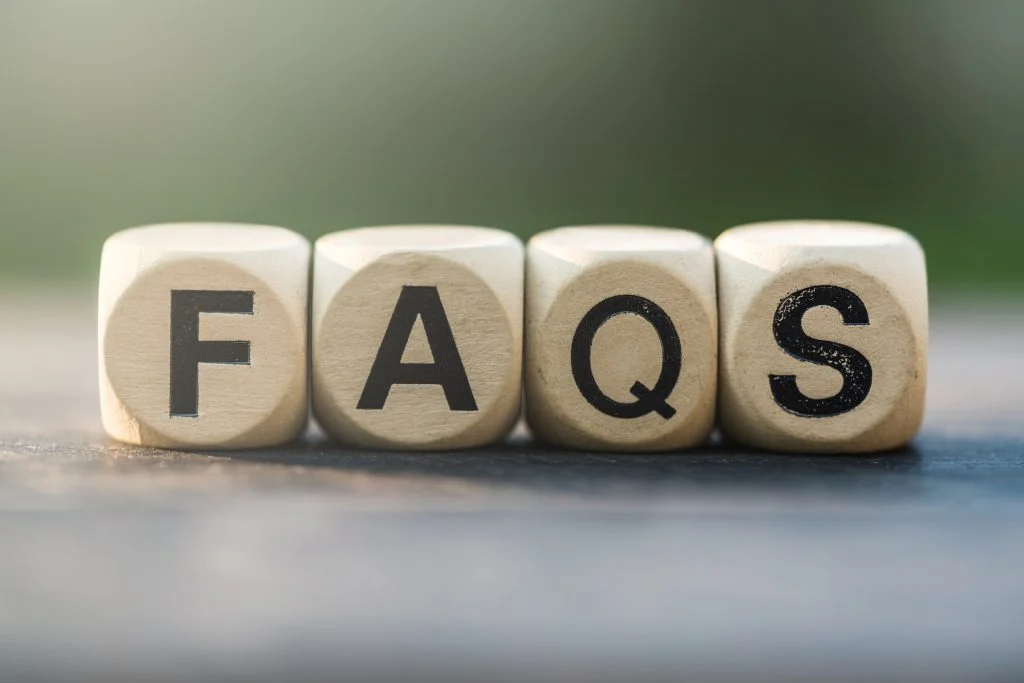 Faqs concept with wooden block on wooden table background