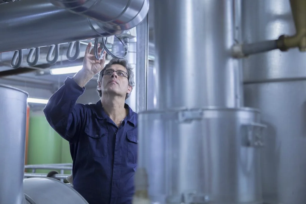 Engineer inspecting pipes in power station