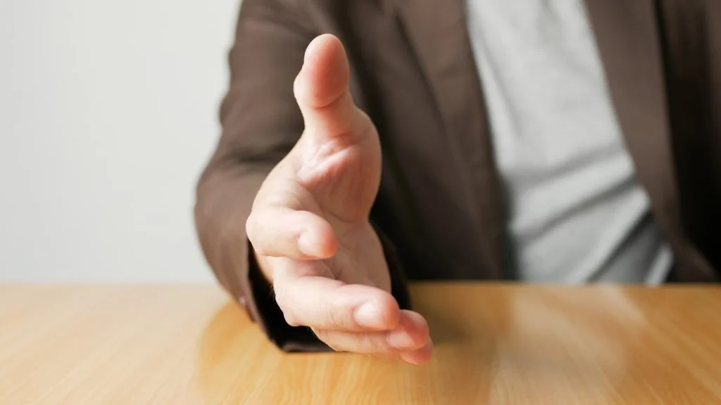Man stretches out his hand for handshake closeup. Conducting business deals concept.