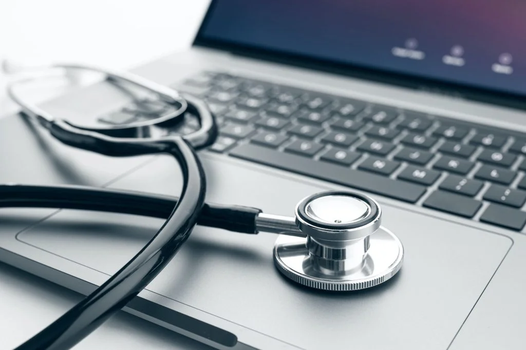 Stethoscope on modern laptop computer
