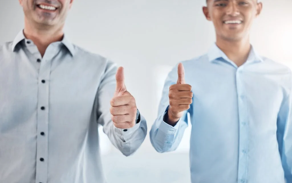 Thumbs up, thank you and motivation with a business man and colleague saying yes in studio on a gra