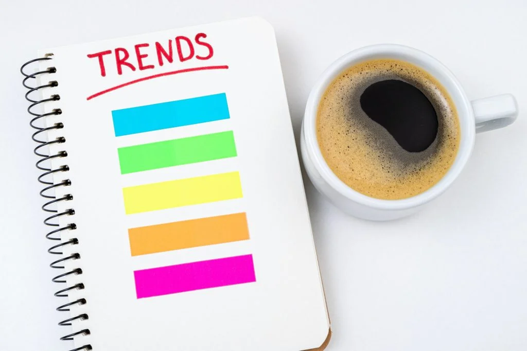 2024 trends business concept. Notebook with trends list, coffee cup on white background